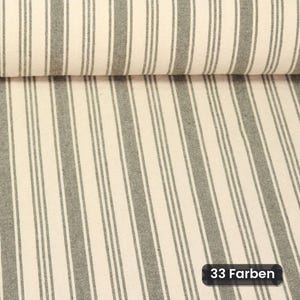Könnte beinhalten: Eine Stoffrolle mit einem sich wiederholenden Muster aus vertikalen dunkelgrauen Streifen auf cremefarbenem Grund. Das Textil zeigt ein durchgehendes lineares Design auf der gesamten Oberfläche mit einem kleinen schwarzen Etikett in der Ecke.