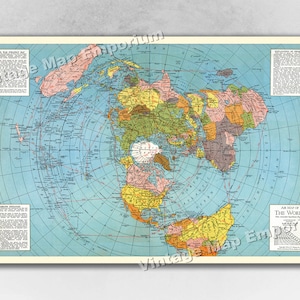May include: An air map of the world with a blue background and colored continents. The map is centered on the North Pole and shows the world as a circle. The map is surrounded by text and a scale bar.