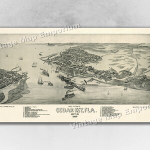 May include: A vintage black and white aerial view map of Cedar Key, Florida, from 1894. The map shows the town's layout, including streets, buildings, and the surrounding water.