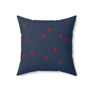 May include: A navy blue cushion with a repeating pattern of small circles and larger red circles.