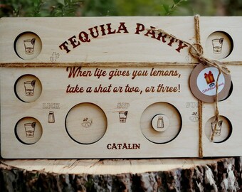 Könnte beinhalten: Holz-Tequila-Party-Spielbrett mit graviertem Text und Illustrationen. Das Brett enthält Platz für Shots, Salz und Limette, mit dem Text "TEQUILA PARTY" und "When life gives you lemons, take a shot or two, or three!"