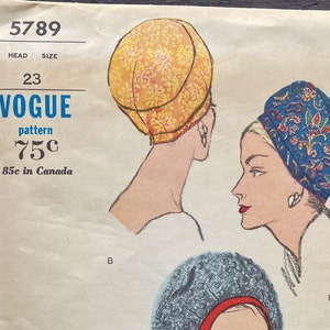 Op de afbeelding: Een vintage Vogue naaipatroon voor drie verschillende hoeden. Het patroon is voor maat 23 en kost 75 cent. De hoeden zijn een gele, een blauwe met witte bloemenprint en een grijze met rode hoed.
