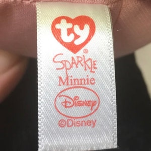 May include: White tag with red text and a red heart with the letters "ty" inside. The tag says "Sparkle Minnie" and has the Disney logo and copyright symbol.