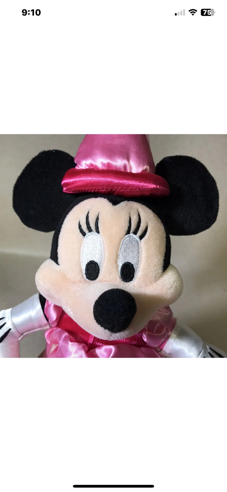 K&ouml;nnte beinhalten: Ein rosa und schwarzes Pl&uuml;schtier von Minnie Mouse, das einen rosa Satin-Hut mit rotem Band tr&auml;gt. Sie hat gro&szlig;e schwarze Augen mit wei&szlig;en Pupillen und lange Wimpern.