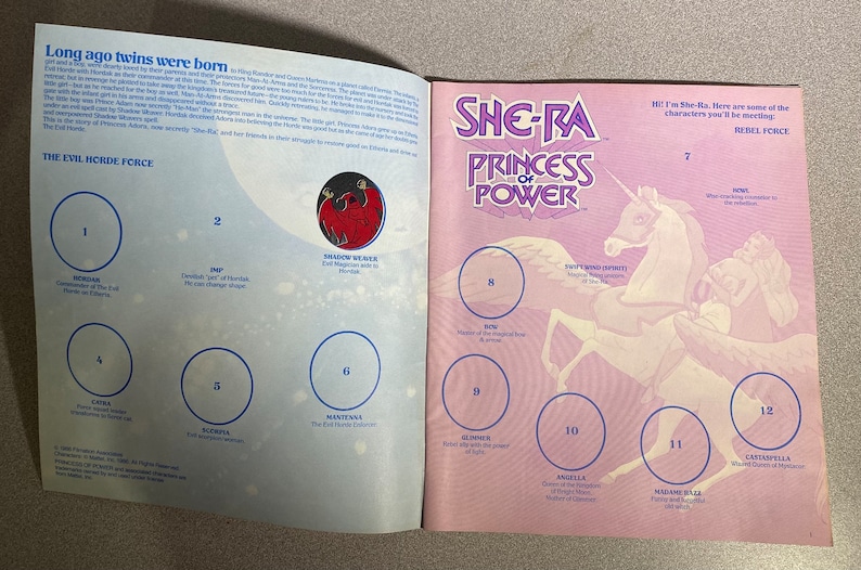 Może przedstawiać: Otwarty album z naklejkami She-Ra: Princess of Power. Lewa strona zawiera tekst i opisy postaci, a prawa ilustracje postaci. Okładka przedstawia logo She-Ra i jednorożca. Nostalgiczny przedmiot kolekcjonerski.