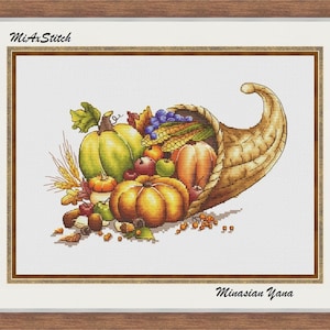 Puede incluir: Un patrón de punto de cruz de una cornucopia rebosante de productos de la cosecha de otoño, incluyendo calabazas, manzanas, uvas, maíz y trigo. La cornucopia es marrón y tejida, y el fondo es blanco. El texto "Mi-A-Stitch" y "Minasian Yana" es visible en la imagen.
