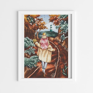 May include: A woman in a beige coat and a white hat walks down a path in a forest. The path is lined with trees and bushes, and the leaves are changing color. The woman is walking towards a small building in the distance.