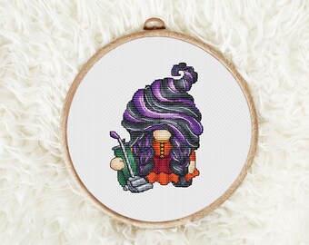 May include: Cross stitch pattern of a witch gnome holding a vacuum cleaner. The gnome has purple and black hair and is wearing a red dress.