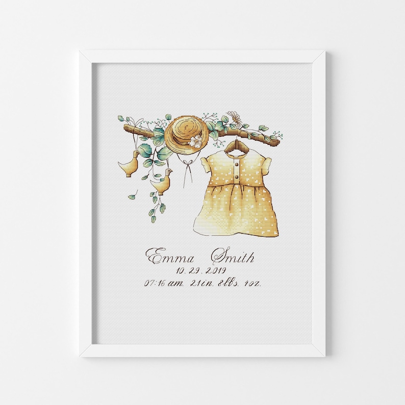 Peut inclure: Une broderie au point de croix encadr&eacute;e repr&eacute;sentant une robe jaune, un chapeau de paille et deux petits oiseaux suspendus &agrave; une branche avec des feuilles vertes. Sous l'illustration, le texte indique Emma Smith, 10.29.2019, 07:16 am, 21in, 8lbs, 4oz.