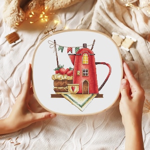Pode incluir: Design de bordado de ponto cruz com um bule vermelho com um design de casa, um pequeno bolo com morangos e uma xícara em forma de coração sobre um fundo branco.