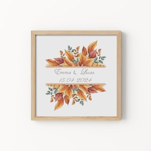 Peut inclure: Un motif de point de croix encadré représentant un bouquet de feuilles orange, rouges et vertes avec le texte "Emma & Lucas 15.04.2024" dans un cadre doré.