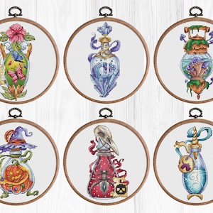 May include: Six embroidered hoop art pieces featuring different potion bottles with various decorative elements. The bottles are filled with colorful liquids and have unique designs, including a skull, a pumpkin, crystals, and mushrooms.
