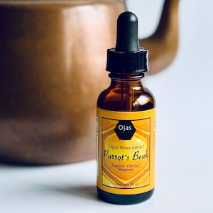 May include: A brown glass bottle with a dropper top and a yellow label that reads "Ojas Naturals Liquid Honey Extract Parrot's Beak Supports "Chill Out" Response 1 fluid ounce (30 ml)"