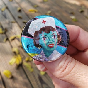 Set of 2 Spooky Nurse pin back buttons, sparkle finish