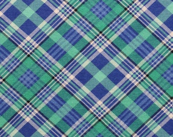 May include: A close-up of a fabric with a plaid pattern. The pattern features a repeating design of intersecting lines in shades of blue, green, and white. The fabric has a diagonal orientation, creating a dynamic visual effect. The overall aesthetic is reminiscent of classic tartan.