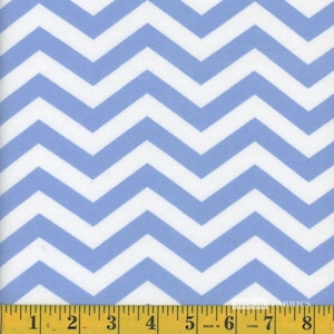 May include: A fabric with a repeating chevron pattern in light blue and white. The pattern is made up of wide, zig-zagging stripes. A yellow measuring tape is at the bottom of the image, with measurements in inches.