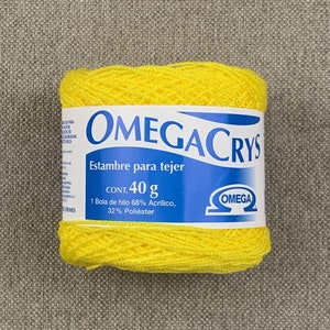 May include: A yellow ball of yarn labeled "OMEGACRYS Estambre para tejer CONT. 40 g 1 Bola de hilo 68% Acrilico, 32% Poliéster OMEGA".