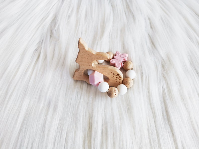 Puede incluir: Un mordedor de madera en forma de ciervo con una mariposa rosa y cuentas de silicona. El mordedor est&aacute; dise&ntilde;ado para beb&eacute;s y ni&ntilde;os peque&ntilde;os.