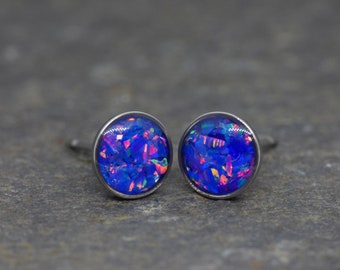 May include: A pair of silver stud earrings with blue opal-like stones. The stones have a shimmery, iridescent effect.