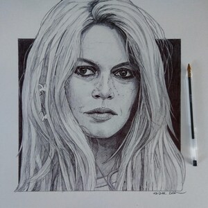 以下が含まれることがあります： 長い金髪の女性の、ペンとインクによる詳細な肖像画。このアートワークは、被写体の顔の特徴（目、唇、そばかすなど）を捉え、詳細な陰影とハイライトを特徴としています。肖像画の隣にペンが置かれています。