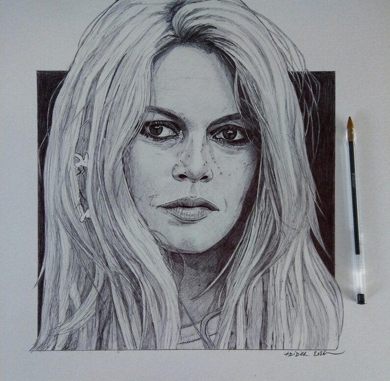 以下が含まれることがあります： 長い金髪の女性の、ペンとインクによる詳細な肖像画。このアートワークは、被写体の顔の特徴（目、唇、そばかすなど）を捉え、詳細な陰影とハイライトを特徴としています。肖像画の隣にペンが置かれています。