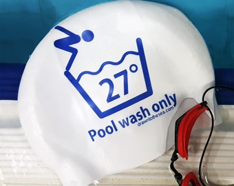 May include: White swim cap with blue text that reads "Pool wash only 27° drawn to the sea.com". A red and black swimming goggle is partially visible in the bottom right corner of the image.