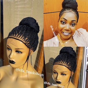 May include: A black braided wig with a high bun. The wig is made with small braids and has a lace front. The wig is on a mannequin head. The text "@ella_braidedwigs" is visible on the image.