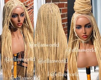 May include: A blonde braided wig with a lace front. The wig is styled in long, straight braids. The wig is on a mannequin head.
