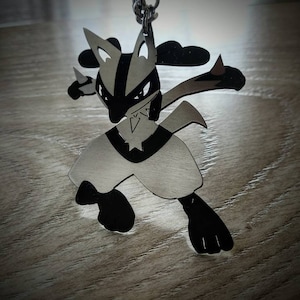 May include: A silver-colored pendant in the shape of a cartoon character with black accents. The pendant is suspended from a silver chain. The character has pointed ears, a black mask, and is in a fighting pose.