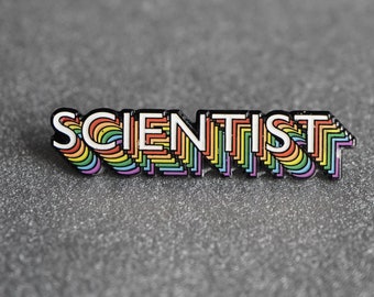 May include: A rainbow-colored enamel pin with the word "SCIENTIST" in white letters.