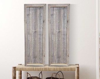 May include: Two framed wood plank wall art prints with a rustic gray and white finish. The prints are displayed on a woven wicker bench with two woven baskets.