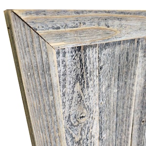 May include: A close-up of a rustic wooden frame with a weathered gray and white finish. The frame is made of reclaimed wood and has a natural, distressed look.