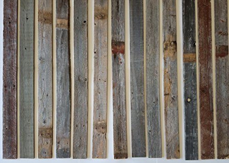 K&ouml;nnte beinhalten: Eine Sammlung von wiederverwendeten Holzbrettern, jedes mit einer einzigartigen verwitterten grauen und braunen Farbe. Die Bretter sind vertikal angeordnet und haben einen rustikalen, abgenutzten Look.