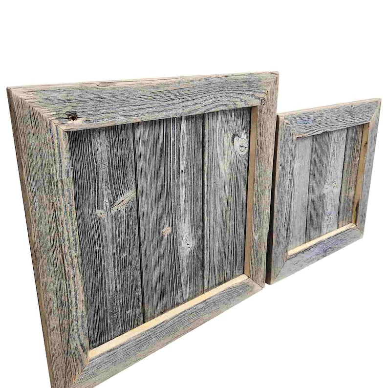 May include: Two rustic wooden picture frames with a distressed gray and white paint finish. The larger frame is slightly angled and the smaller frame is positioned to the right of the larger frame.