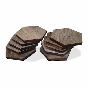 May include: A set of 10 hexagonal wooden coasters in shades of brown and gray. The coasters are stacked in two piles, with the top coaster of each pile facing the camera.