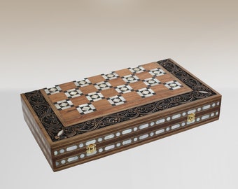 Peut inclure: Un plateau de jeu de backgammon en bois avec des incrustations complexes de nacre et de laiton. Le plateau est fermé et présente un design traditionnel.