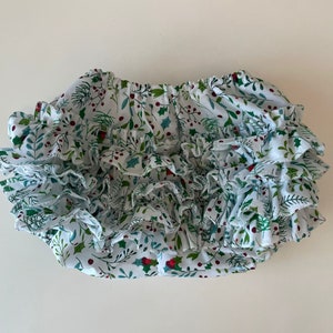 Op de afbeelding: Witte geruite bloomer met een groene en rode print van hulstbesjes.