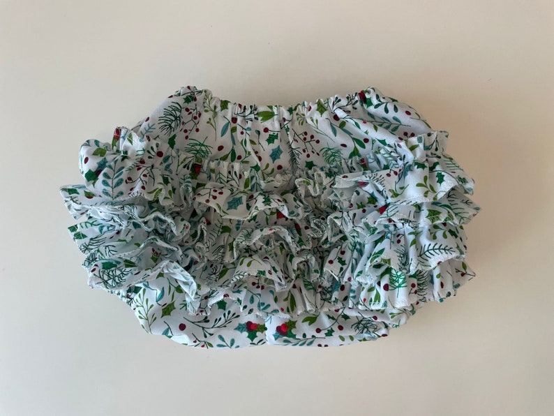 Op de afbeelding: Witte geruite bloomer met een groene en rode print van hulstbesjes.