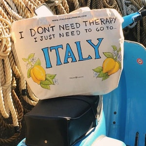 Tote bag with the quote I don't need therapy, I just need to go to Italy, flanked by Amalfi Coast lemons. Designed and sold by Italian Summers