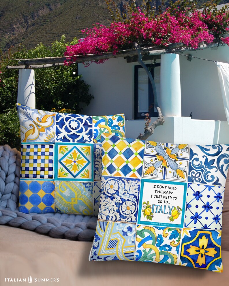 May include: Two decorative throw pillows with a patchwork design of blue, yellow, and white tiles. The pillows feature a quote that reads "I don't need therapy I just need to go to Italy".