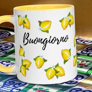 May include: White ceramic mug with a yellow rim and handle. The mug features a lemon design and the text "Buongiorno".