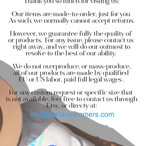 May include: A white t-shirt with a blue graphic of the island of Capri, Italy. The text "Capri Isola Dell'Amore" is printed on the shirt. The shirt is being worn by a person lying on a beach.