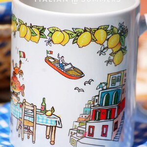 May include: White ceramic mug with a colorful illustration of a boat, a small town, and a table with a chair. The mug has the text "ITALIAN SUMMERS" printed on the top.