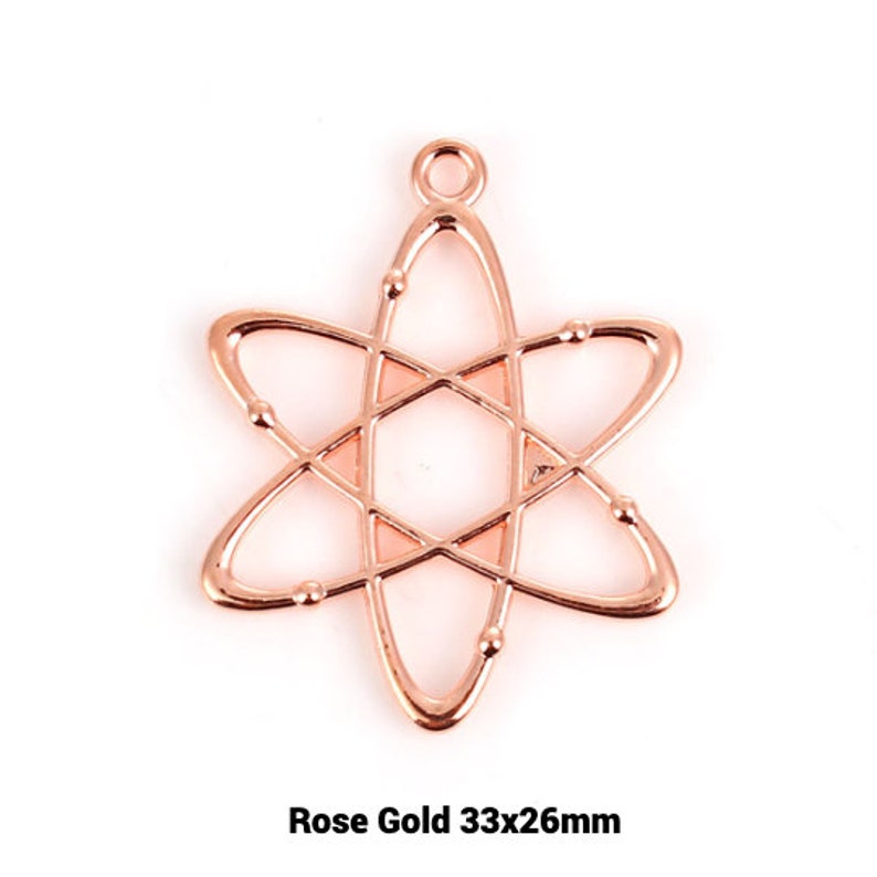 May include: Rose gold atom charm pendant measuring 33mm by 26mm. The charm is a delicate, openwork design with a detailed atom shape.