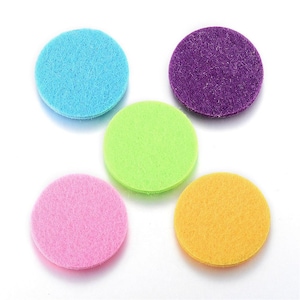 May include: Five round felt pads in different colors: light blue, purple, green, pink, and yellow. The pads are about 2 inches in diameter and are made of a soft, fuzzy material.