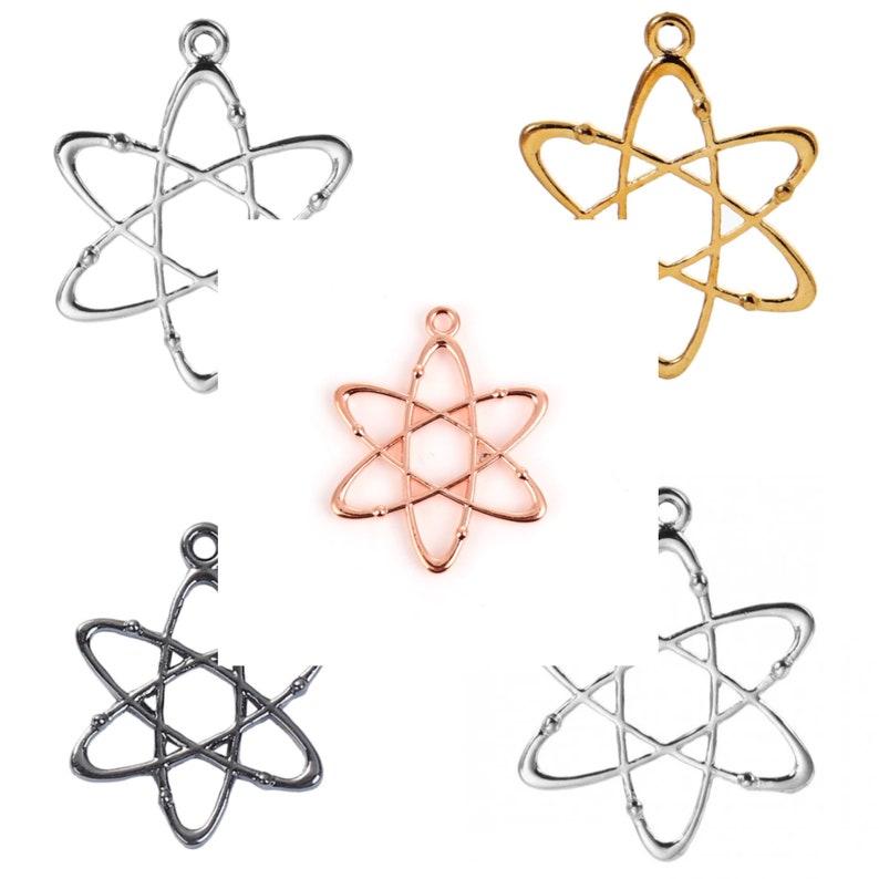May include: Five atom charm pendants in different colours: silver, gold, rose gold, black, and white. The charms are all the same design, a stylised atom with a circle in the centre and six points.