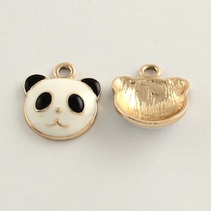 May include: Two panda-shaped charms. The front of the charm features a panda face with black ears, eyes, and a nose on a white background, outlined in gold. The back is gold-colored.