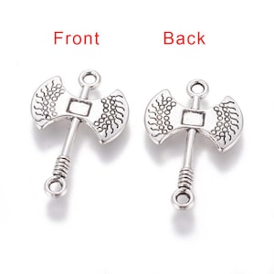 May include: Two silver-toned axe charms with a loop at the top for attaching to jewelry or crafts. The axe heads have a detailed design and the handles are twisted.