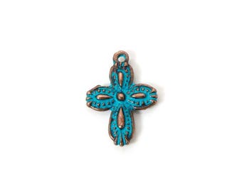 May include: A turquoise and bronze-colored cross pendant. The cross features a detailed design with a loop at the top for hanging. The pendant has a distressed, vintage appearance, with a mix of turquoise and bronze tones.