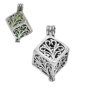 May include: Silver charm with a filigree design in the shape of a cube. The charm is open on one side and has a loop at the top for attaching to a necklace or bracelet.